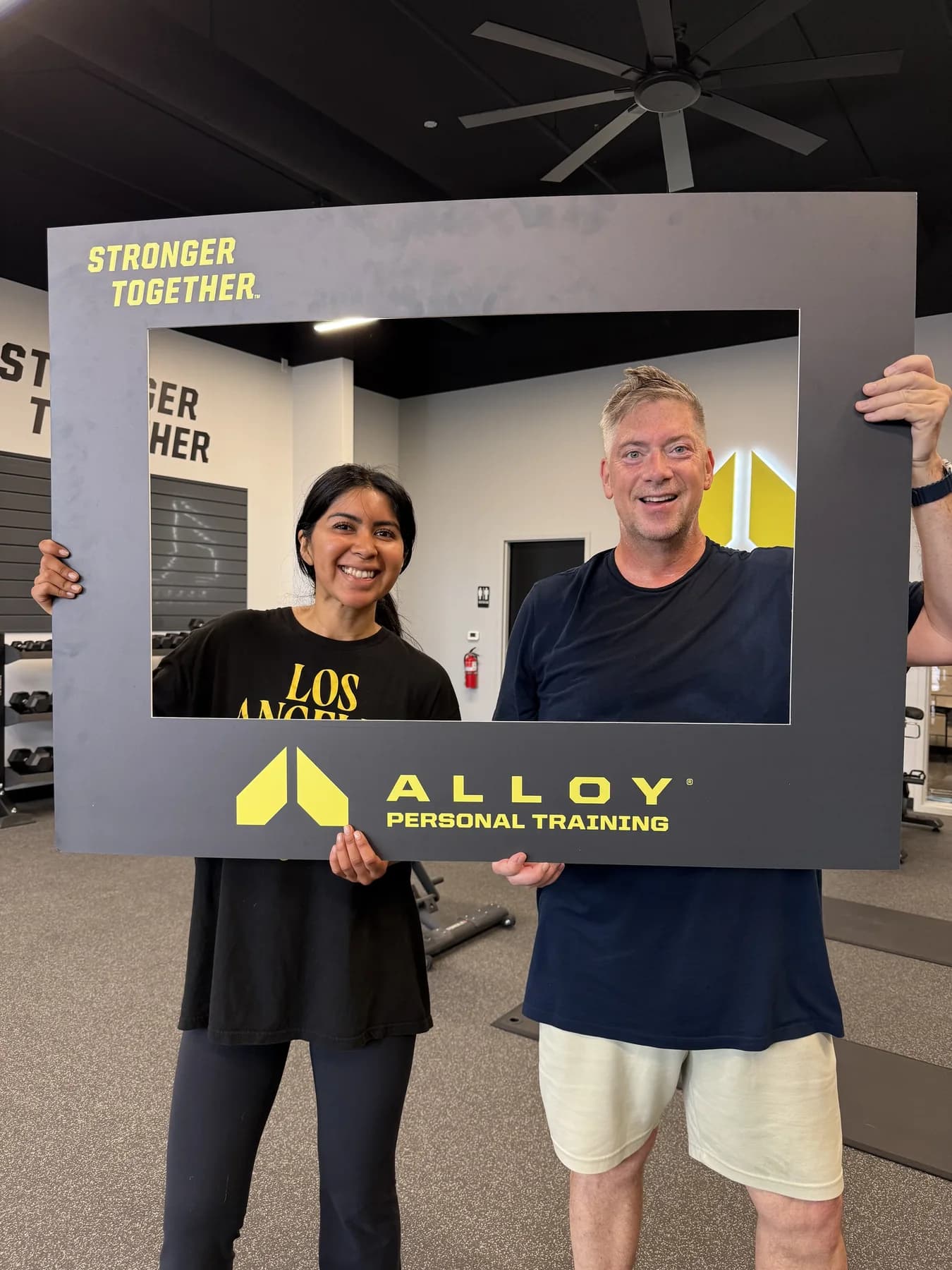 Two community members smiling through the Alloy photo frame