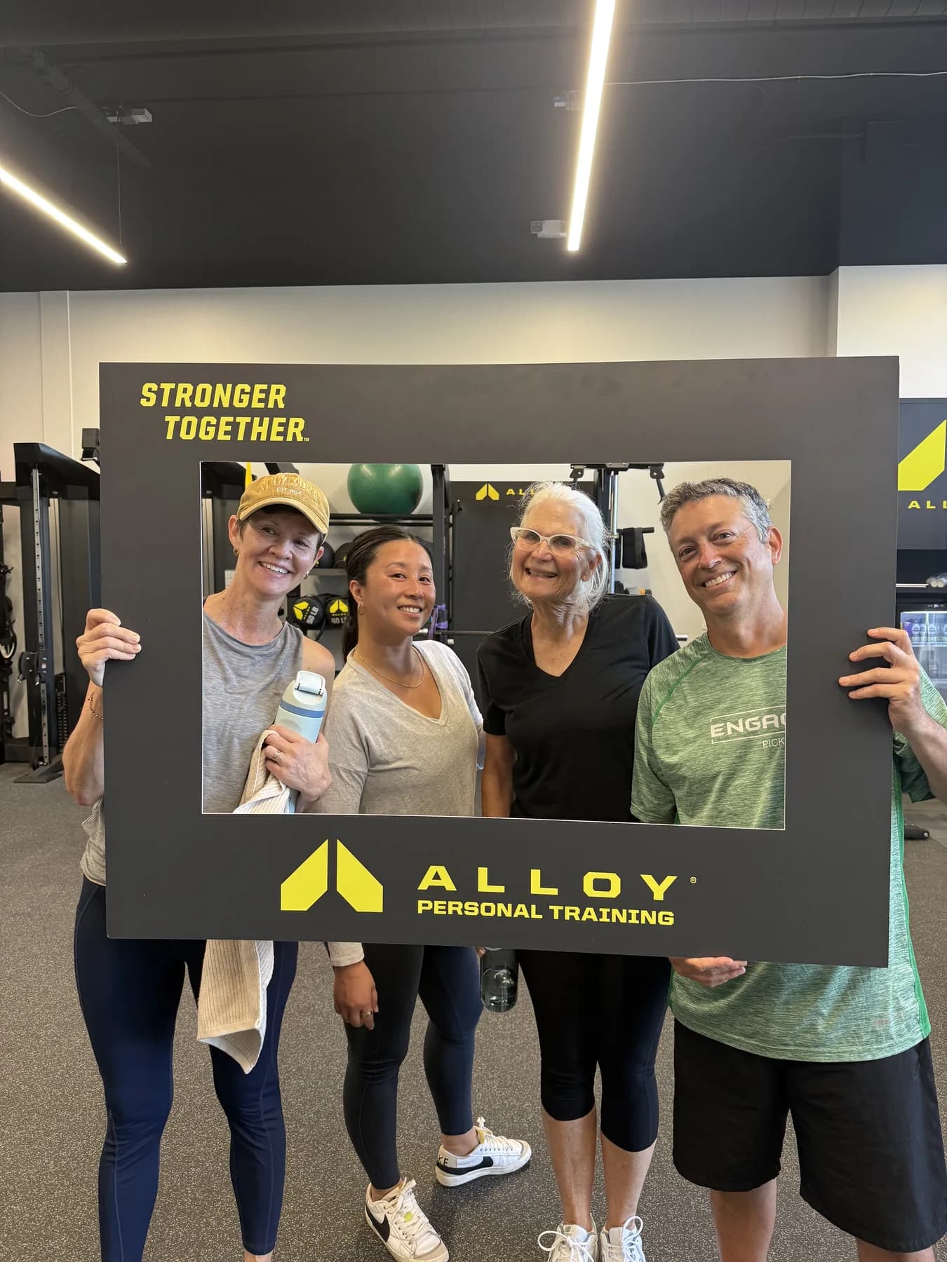 Four community members smiling through the Stronger Together frame