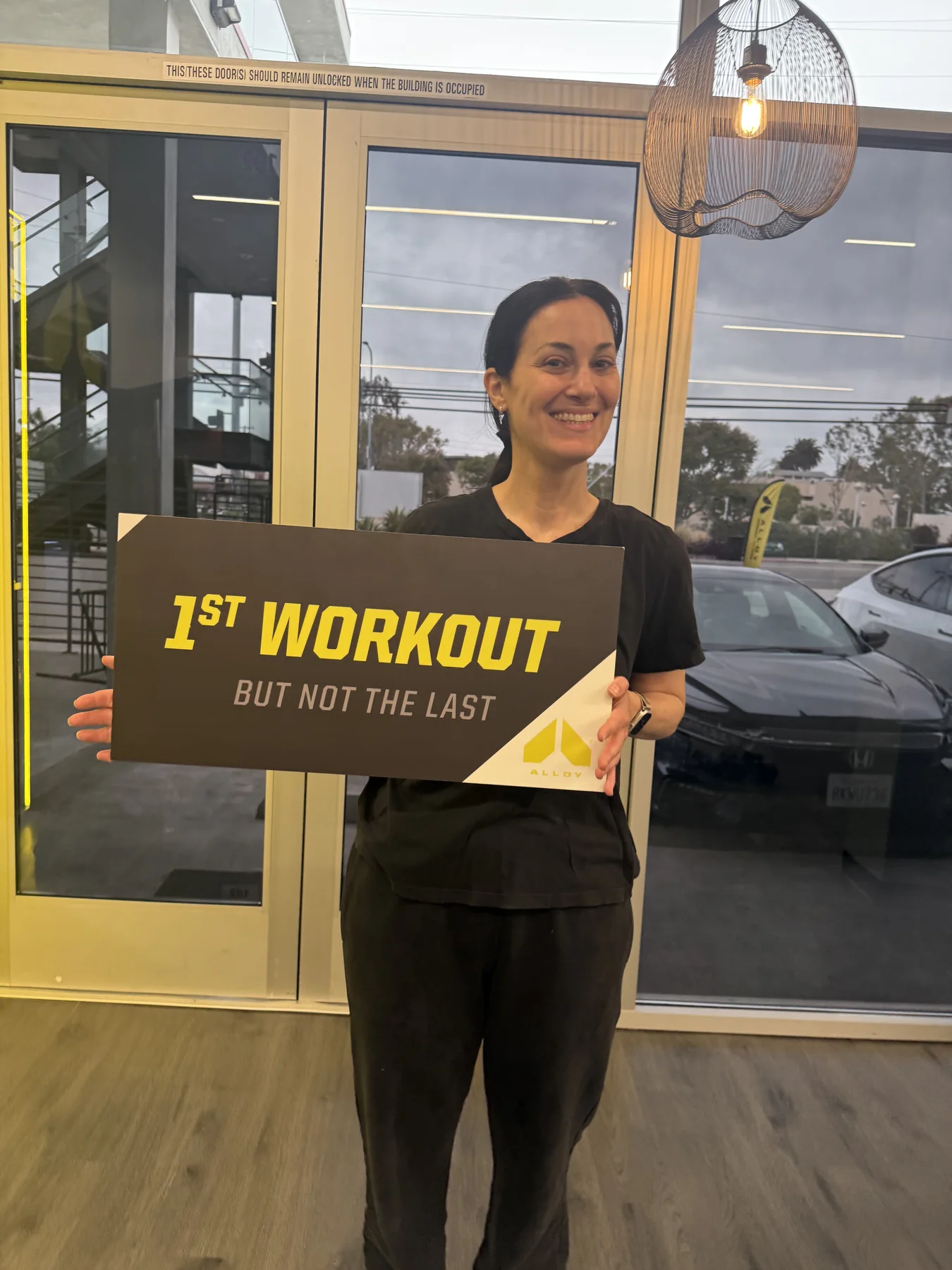 A member holding the first-workout sign inside the studio