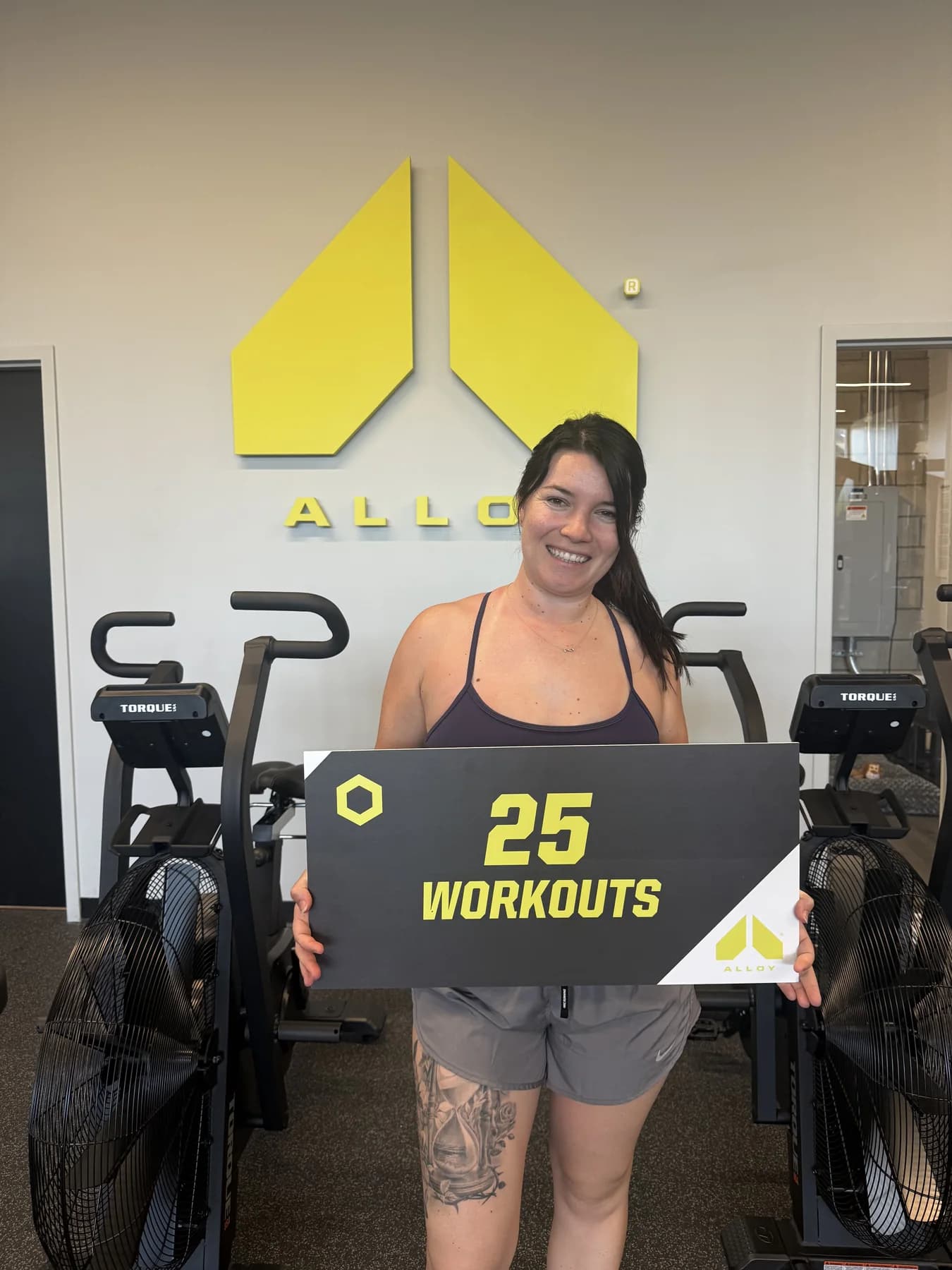 A member celebrating twenty-five workouts beneath the Alloy logo