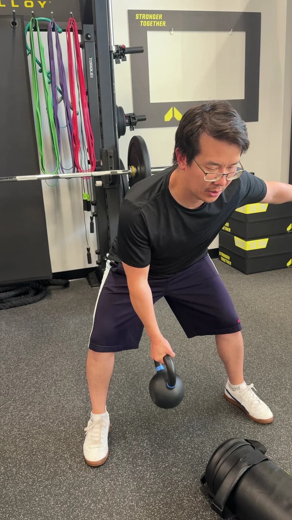 A member performing a single-arm kettlebell row