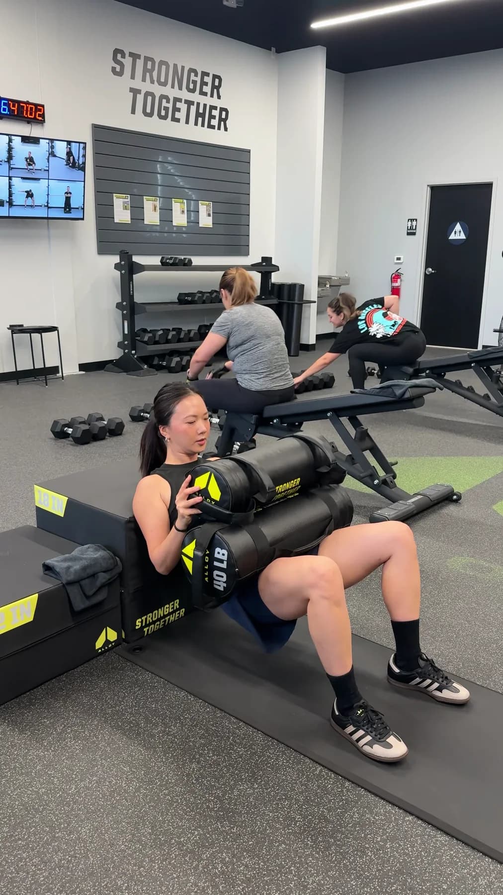A member completing a weighted core exercise during a session
